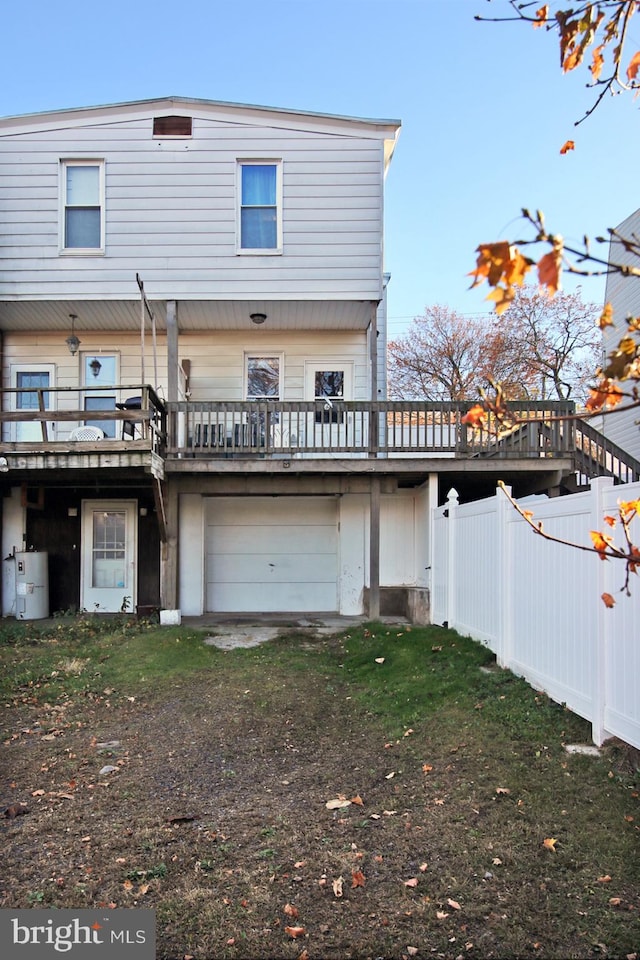 rear view of house with a deck and a garage