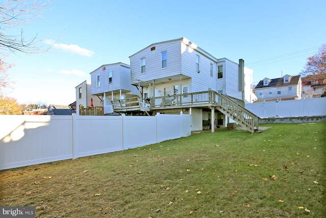 rear view of house with a yard and a wooden deck