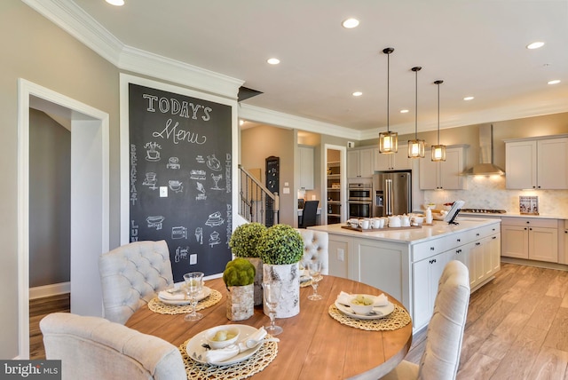 dining area featuring crown molding and light hardwood / wood-style flooring