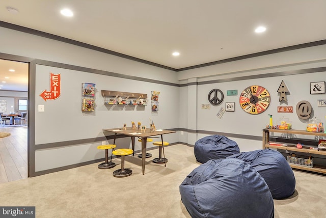 game room with wood-type flooring and crown molding