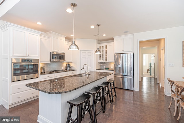 kitchen featuring white cabinetry, sink, stainless steel appliances, dark hardwood / wood-style floors, and backsplash