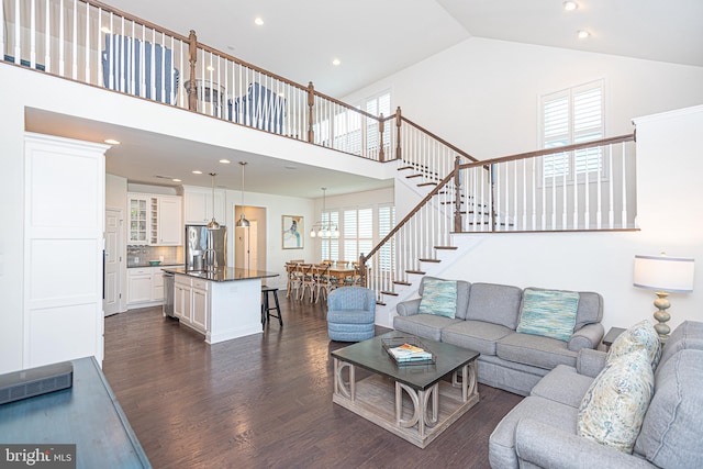 living room with dark hardwood / wood-style flooring and high vaulted ceiling