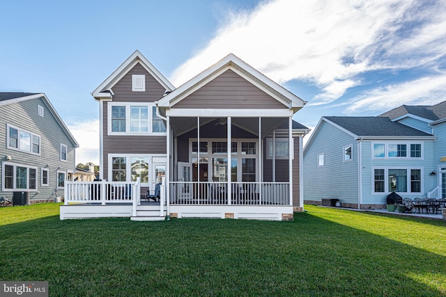 rear view of property featuring a sunroom, a yard, and central AC unit