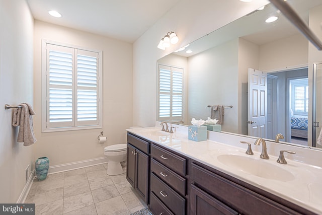 bathroom with plenty of natural light, toilet, and vanity