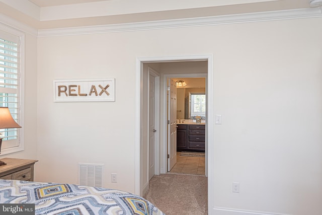 bedroom featuring light carpet and crown molding