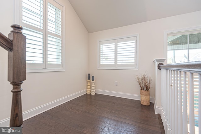 spare room with dark hardwood / wood-style floors and lofted ceiling