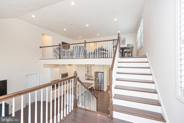 stairway with wood-type flooring and vaulted ceiling