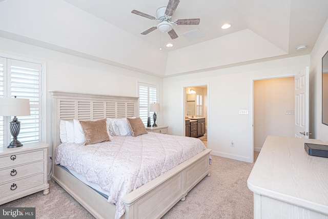 bedroom with multiple windows, ensuite bathroom, ceiling fan, and light colored carpet