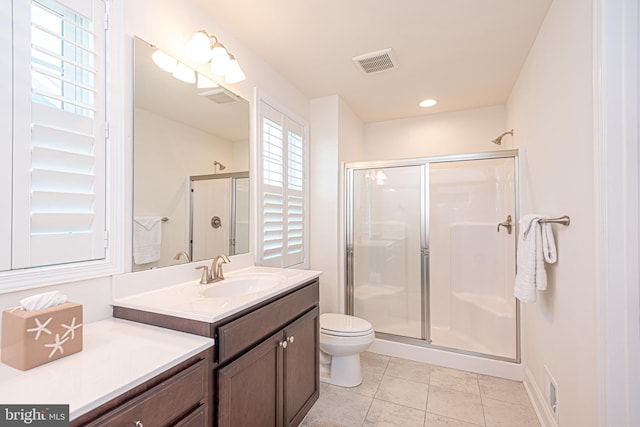 bathroom with vanity, toilet, an enclosed shower, and a wealth of natural light