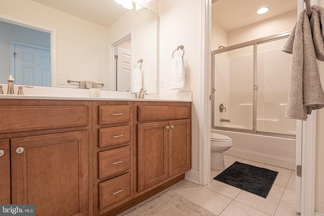 full bathroom with shower / bath combination with glass door, tile patterned flooring, vanity, and toilet