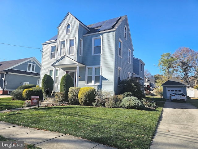 view of front of house with driveway, a front yard, a detached garage, and an outdoor structure