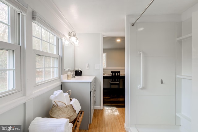 bathroom with wood-type flooring, vanity, and walk in shower