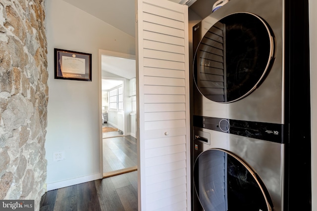 laundry area with stacked washer / dryer and dark hardwood / wood-style flooring