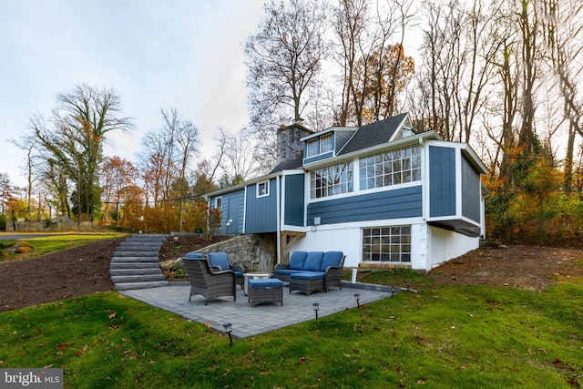 back of property with a lawn, a sunroom, an outdoor hangout area, and a patio