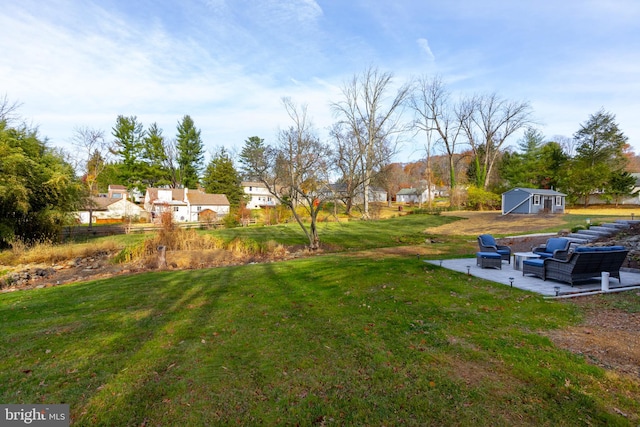 view of yard featuring outdoor lounge area, an outbuilding, and a patio