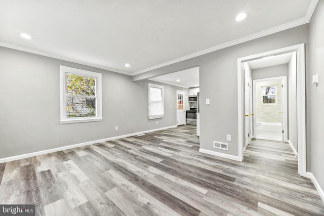 unfurnished living room featuring crown molding and light hardwood / wood-style floors