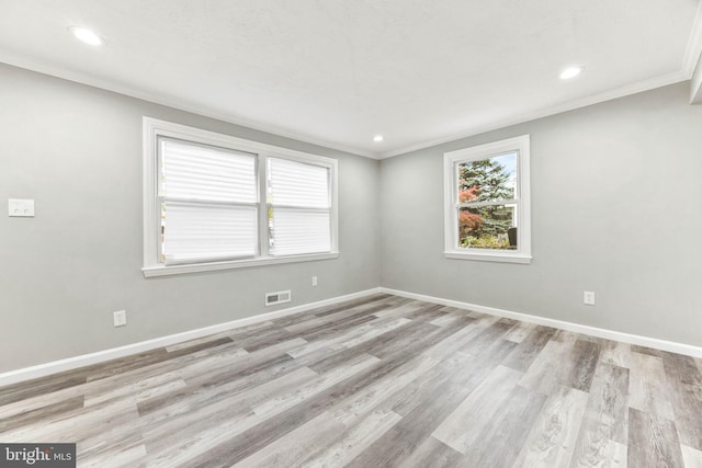 empty room with light wood-type flooring and ornamental molding