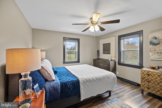 bedroom featuring ceiling fan, wood-type flooring, and multiple windows