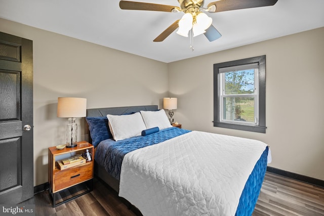 bedroom with dark hardwood / wood-style flooring and ceiling fan