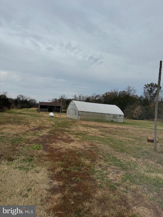 view of yard with a rural view and an outdoor structure