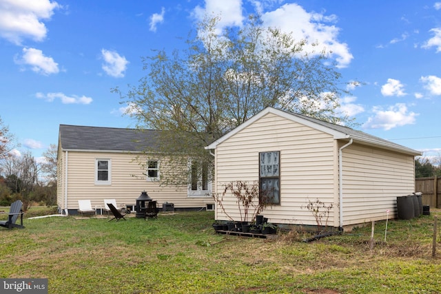 back of house featuring a yard and central AC unit