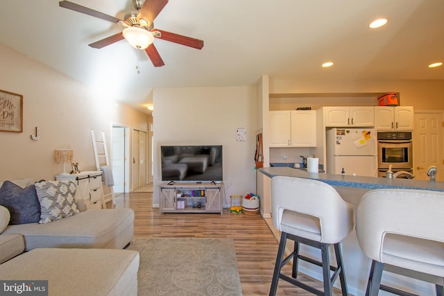 kitchen with light hardwood / wood-style floors, white refrigerator, oven, ceiling fan, and white cabinetry