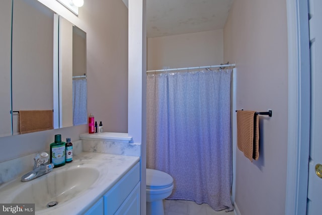 bathroom with toilet, vanity, and tile patterned floors