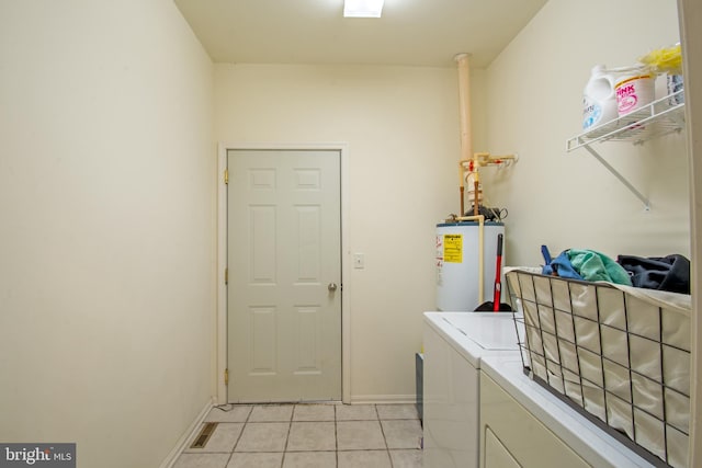 laundry area with water heater, light tile patterned flooring, and washer and clothes dryer