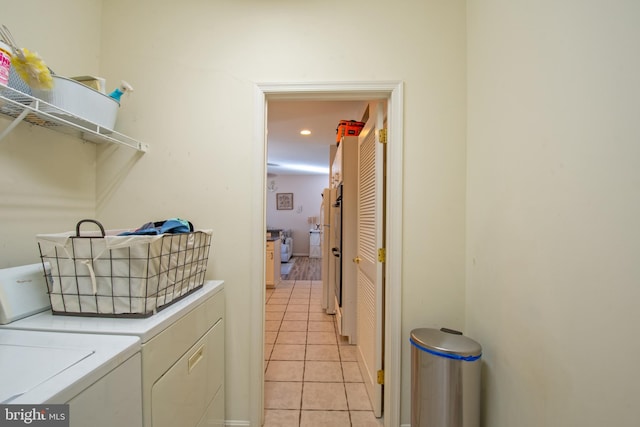 laundry area with washing machine and dryer and light tile patterned floors