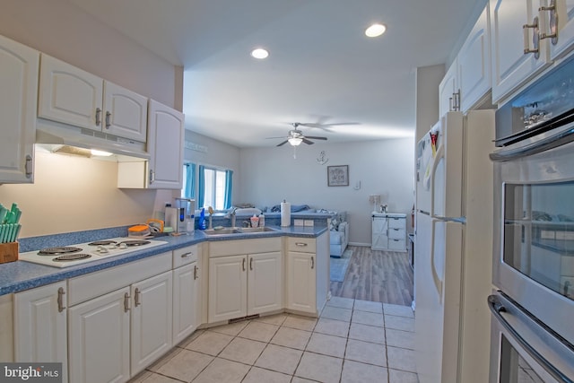 kitchen with white cabinetry, white appliances, light tile patterned floors, and kitchen peninsula