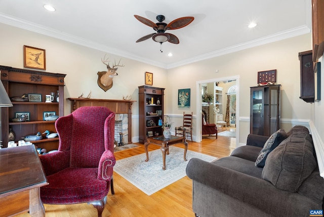 living room with ornamental molding, light hardwood / wood-style floors, and ceiling fan