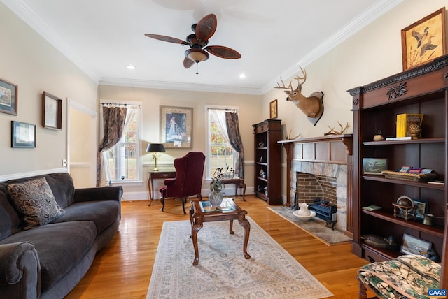 living room featuring ceiling fan, crown molding, and light hardwood / wood-style flooring