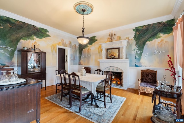 dining area featuring a brick fireplace, light hardwood / wood-style floors, and ornamental molding