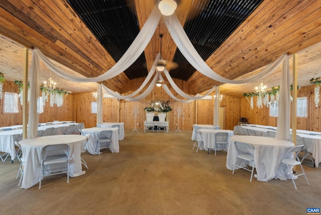 dining area featuring a chandelier, plenty of natural light, and wooden walls