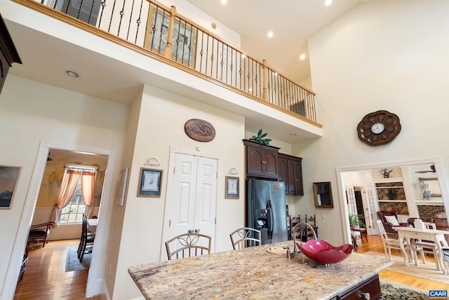 dining space featuring hardwood / wood-style floors and a high ceiling