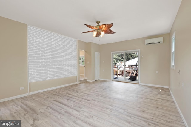 unfurnished room with ceiling fan, a wall unit AC, and light hardwood / wood-style flooring