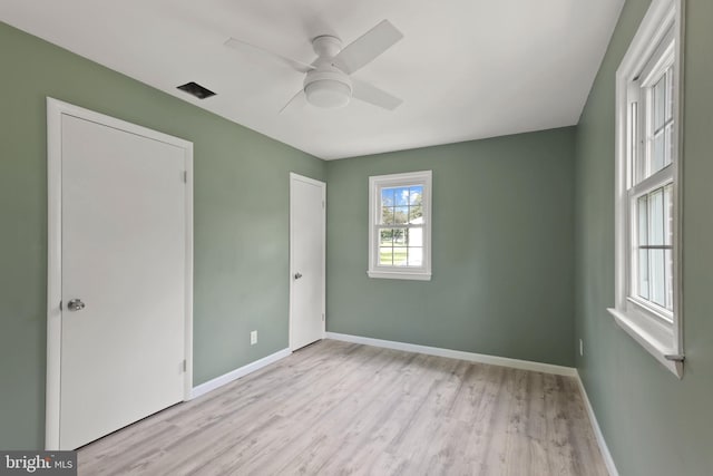 spare room with light wood-type flooring and ceiling fan