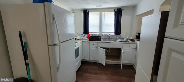 kitchen featuring dark hardwood / wood-style floors, white appliances, white cabinets, and sink