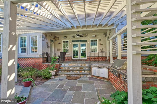 property entrance featuring ceiling fan, a patio area, exterior kitchen, and a pergola