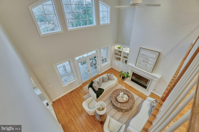 17061 Spring Creek Ln, Leesburg, VA 20176 - living area with a high ceiling, french doors, a fireplace with flush hearth, wood finished floors, and ceiling fan