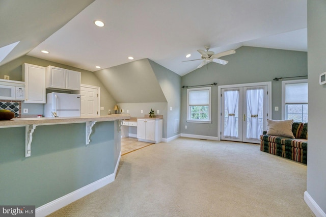 17061 Spring Creek Ln, Leesburg, VA 20176 - kitchen with white appliances, a kitchen breakfast bar, lofted ceiling, white cabinets, and baseboards