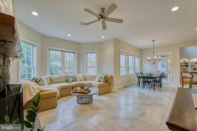 living room featuring a wealth of natural light, light tile patterned floors, and ceiling fan with notable chandelier