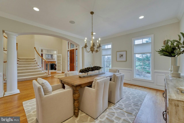 dining area featuring a notable chandelier, light wood-type flooring, and ornamental molding