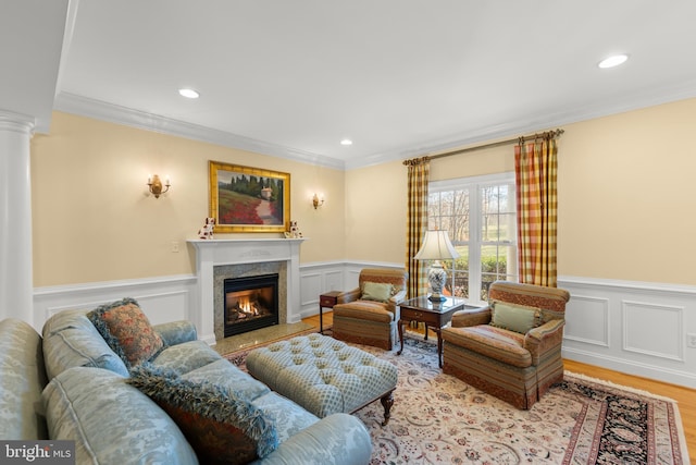 living room featuring crown molding, a high end fireplace, and light hardwood / wood-style flooring