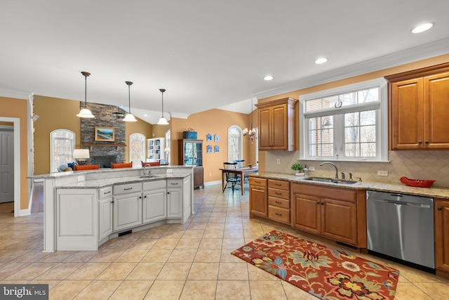 kitchen with stainless steel dishwasher, a kitchen island, crown molding, and sink