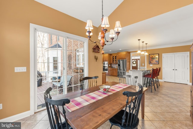 tiled dining area featuring ornamental molding and a notable chandelier