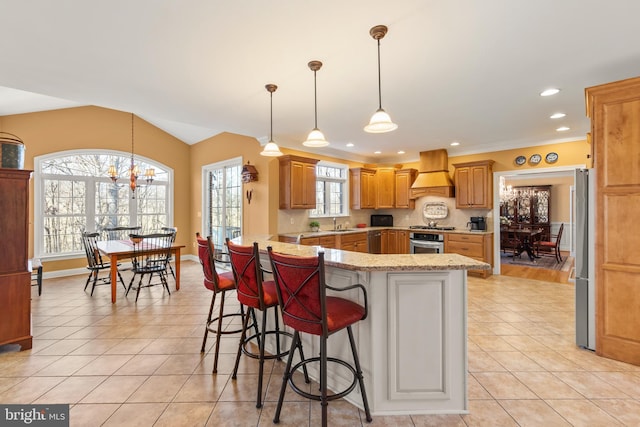 kitchen featuring custom exhaust hood, a kitchen bar, plenty of natural light, and kitchen peninsula