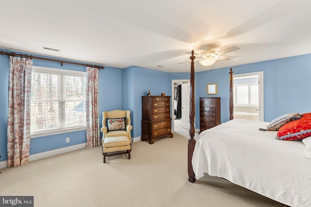 carpeted bedroom featuring ensuite bath and ceiling fan