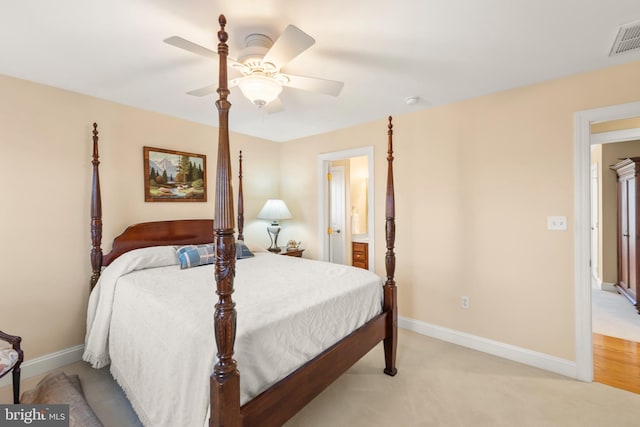 carpeted bedroom with ensuite bath and ceiling fan