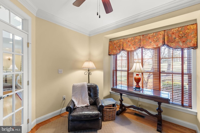 living area featuring ceiling fan, wood-type flooring, and ornamental molding